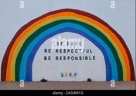 Painted wall with a rainbow and be safe, be respectful, be responsible motivational words Stock Photo