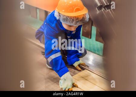 Boy plays in a children s construction site. Stacking parquet Stock Photo