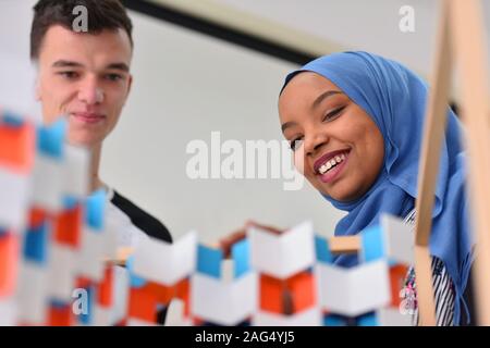 Two beautiful  university  multireligion and multiethnic architecture students working on practice lessons. Helping each other during class. Stock Photo