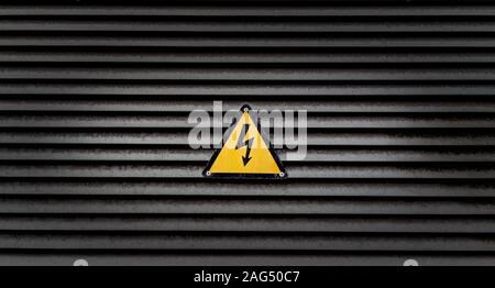 Yellow danger sign on a black striped wall Stock Photo