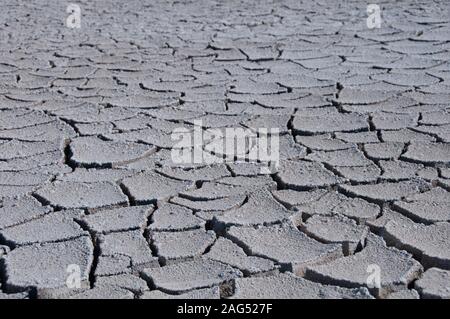 High angle greyscale shot of a cracked stony ground in a deserted area Stock Photo