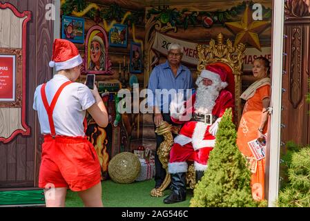 People having photos with Santa Claus at Christmas Square at Federation Square in Melbourne, Australia Stock Photo