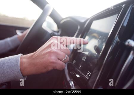 Man using navigation system while driving a car. Transport, destination, modern technology and people concept - male hand searching for route using na Stock Photo