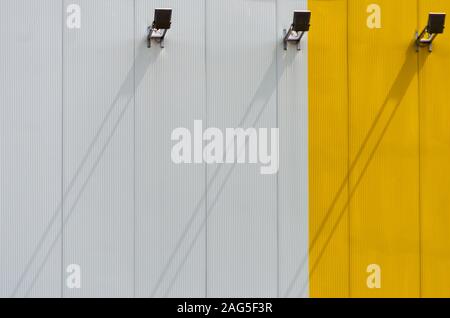 Shadow of three lamps on a textured white and yellow wall Stock Photo