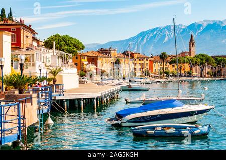 Toscolano Maderno, Lombardy, Italy - September 12, 2019: View on sailing yachts and boats parked on crystal clear blue water of amazing lake Garda and Stock Photo