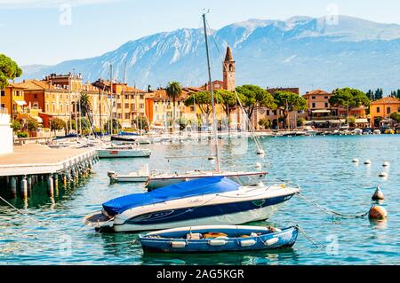 Toscolano Maderno, Lombardy, Italy - September 12, 2019: View on sailing yachts and boats parked on crystal clear blue water of amazing lake Garda and Stock Photo