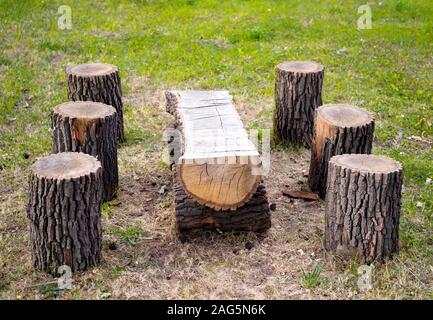 Wooden table and stools made from tree logs outdoors Stock Photo