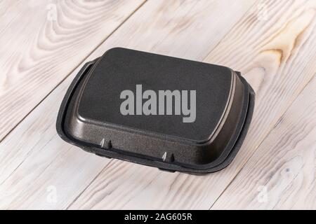 Plastic container on wood background. Closed food tray with lid. Stock Photo