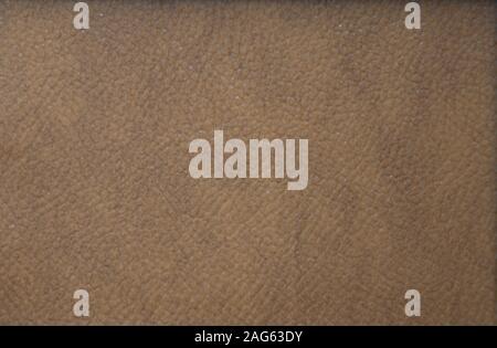 The grained texture of genuine leather is rough, artificially painted in dark brown. Background. Stock Photo