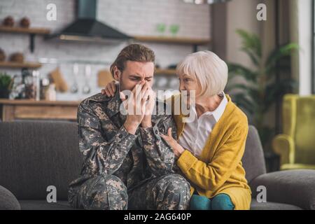 Psychological problems. Young handsome man in camouflage looking stressed Stock Photo