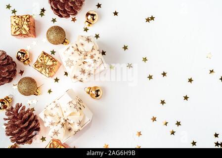 Christmas composition. Christmas golden decor, pine cone, star on white background. Flat lay, top view, copy space Stock Photo