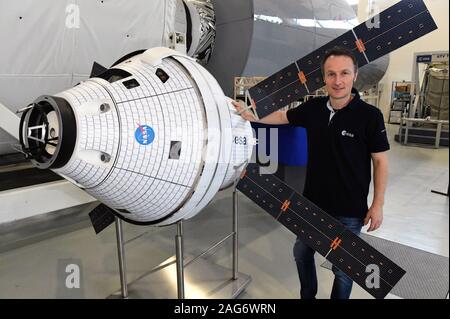 10 December 2019, North Rhine-Westphalia, Cologne: Astronaut Matthias Maurer stands next to a model of the Orion space capsule at the European Astronaut Centre (EAC) on ESA premises. Photo: Felix Hörhager/dpa Stock Photo