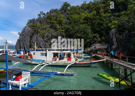 Day trippers disembarking a traditional outrigger boat used  on Island Hopping Tours,Coron,Philippines Stock Photo