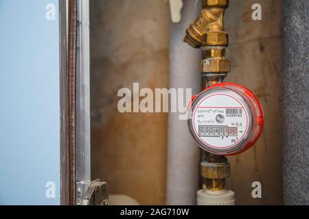 Hot water meter with filter on pipe in flat. Municipal water metering Stock Photo