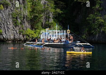 Day trippers aboard a traditional outrigger boat used  on Island Hopping Tours,Coron,Philippines Stock Photo