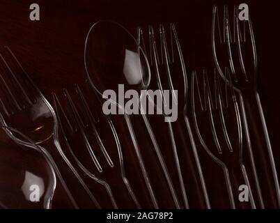 Transparent plastic spoon and fork on wooden table Stock Photo