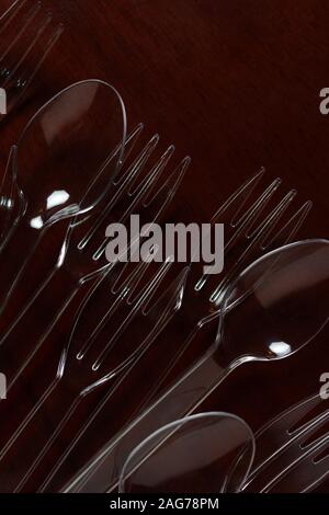 Transparent plastic spoon and fork on wooden table Stock Photo