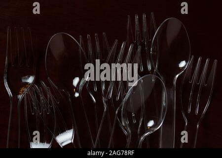 Transparent plastic spoon and fork on wooden table Stock Photo