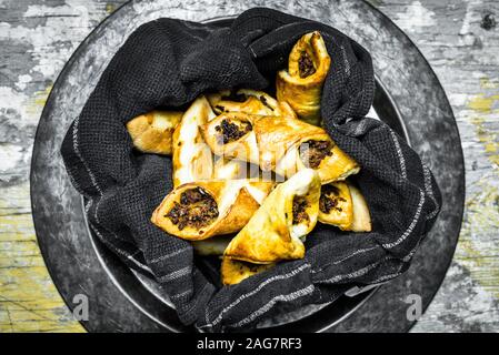 High angle shot of meat pies in a bowl with a black blanket - Granny's pies childhood memory Stock Photo