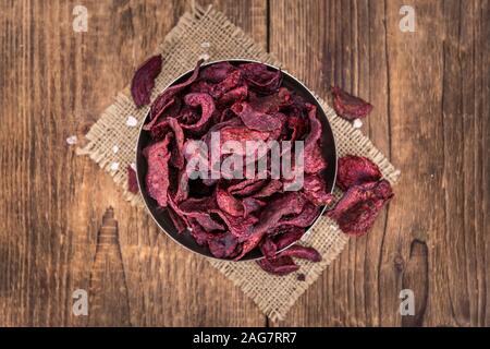 Wooden table with Beetroot Chips (detailed close-up shot; selective focus) Stock Photo