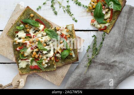 High angle shot of pieces of Sicilian pizza with different kinds of vegetables on a white surface Stock Photo