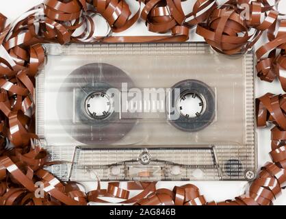 Vintage transparent Compact Cassette with pulled out tape audio background Stock Photo