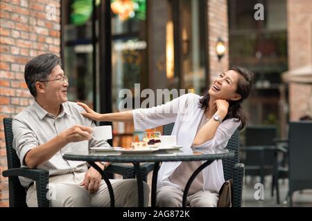 Mature Chinese couple having afternoon tea in coffee shop Stock Photo