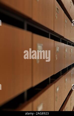 Vertical shot of lines of small wooden lockers - perfect for an article about campus life Stock Photo