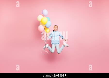 Full length body size photo of cheerfu positive cute nice screaming funny comic girl holding balloons with hands shouting flying jumping in blue