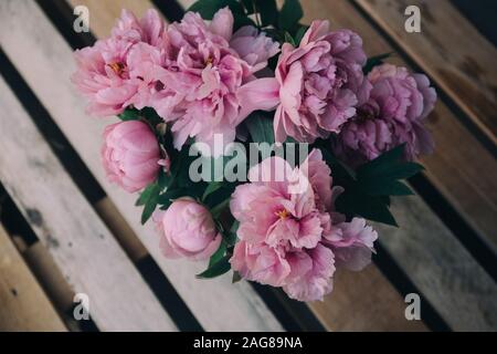 High angle closeup shot of elegant pink peonies on a wooden ground Stock Photo