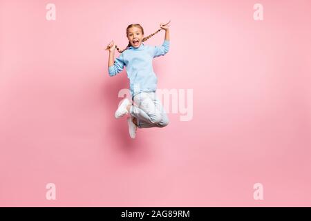Full length body size photo of cheerful positive ecstatic overjoyed rejoicing girl jumping up wearing jeans denim blue sweatshirt sweater isolated Stock Photo