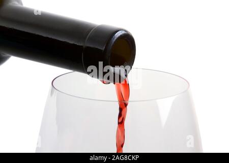 drink at the bar - the jet of red wine from the bottle to the glass Stock Photo