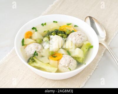 bowl of soup, a cup of broth and vegetables, meatballs made of turkey and a chicken, top view Stock Photo