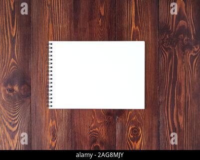 The open notepad with spiral on dark brown wooden table, top view Stock Photo