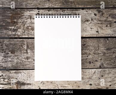 open notepad with clean white page on the aged old rustic wooden table, top view Stock Photo