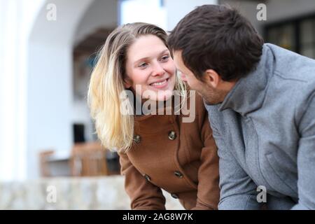 Happy couple of adults dating talking and flirting in winter in the street Stock Photo