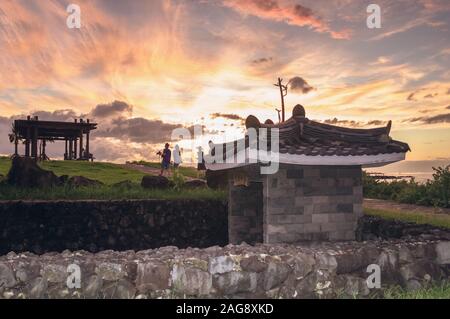 Jeju, South Korea, september 09, 2019: Family and friends are going to the Hamdeok Beach with stunning sunset on background and traditional korean bui Stock Photo