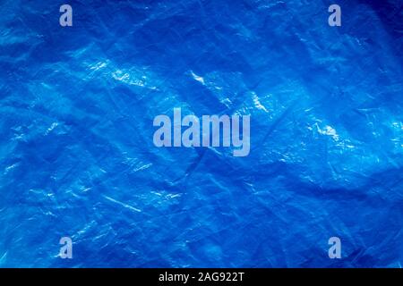 Texture of crumpled blue plastic trash bag. Abstract background for design with copy space.