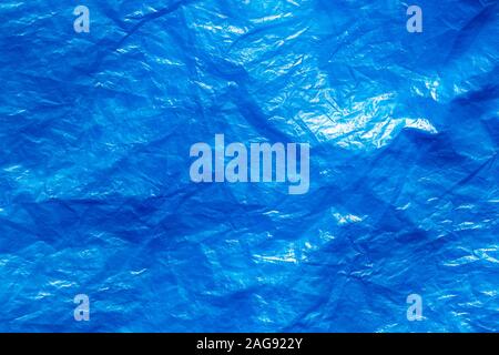 Texture of crumpled blue plastic trash bag. Abstract background for design with copy space.