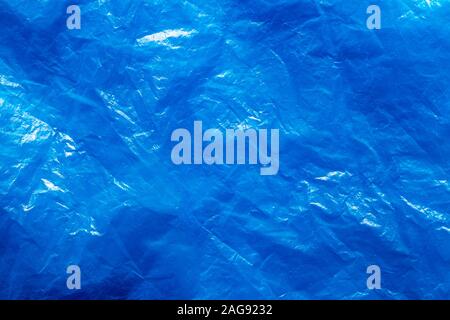 Texture of crumpled blue plastic trash bag. Abstract background for design with copy space. Stock Photo