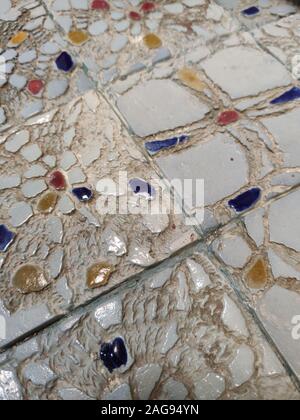 Vertical high angle shot of cobblestone floor tiles with a few colorful stones Stock Photo