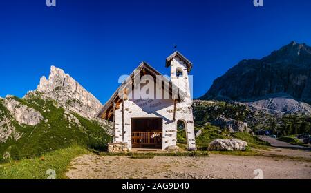 A small chapel and the summits of Lagazuoi and Sass de Stria at Falzarego Pass, Passo di Falzarego Stock Photo