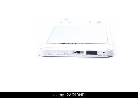 A cell phone with an open cover lies face down on a white background. Cell phone repair service. Stock Photo