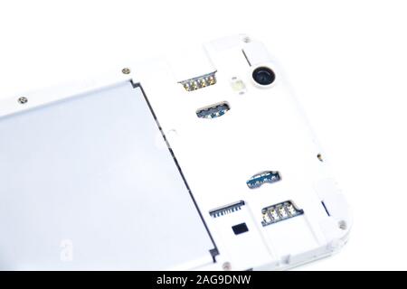 A cell phone with an open cover lies face down on a white background. Cell phone repair service. Stock Photo