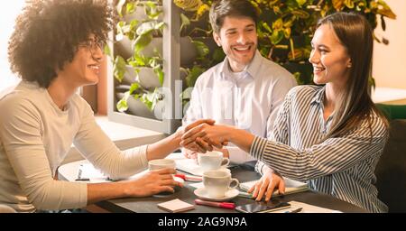 New business partners handshaking during alive meeting in cafe Stock Photo