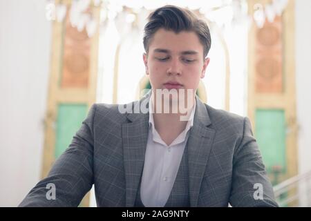 Religious young hafiz muslim man praying inside the mosque and reading holy book of qoran or koran. Stock Photo