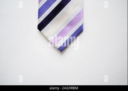 Overhead shot of a striped tie on a white surface Stock Photo
