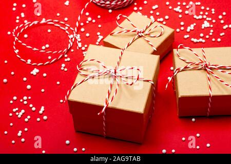 Minimalistic Christmas gift wrapping on the red background. Merry Christmas, New Year, winter, zero waste concept. Stock Photo