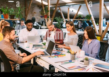 Team of designers working on laptops in modern office Stock Photo