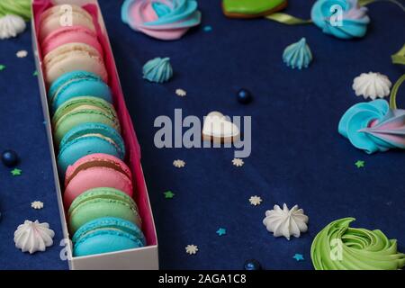 Tasty multi-colored sweet macaroons in a white gift box on a classic blue background, horizontal orientation Stock Photo